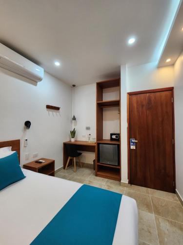 阿约拉港CASA GALAPAGOS by Hostal Fragata的一间酒店客房,配有一张床、一张桌子、一张床和一扇门