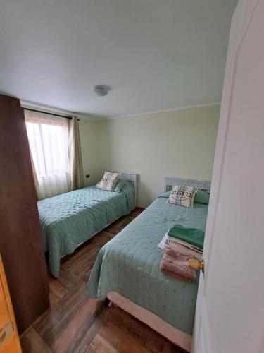 奥索尔诺Cabañas ruta internacional 215 I, Osorno的一间卧室设有两张床和窗户。