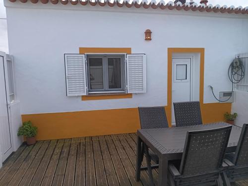 阿尔热祖尔Sunny Aljezur da Viana, (Aljezur, Costa Vicentina)的客房设有桌椅和窗户。