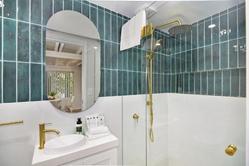 尤米纳Palm Cove Retreat的带淋浴、盥洗盆和镜子的浴室