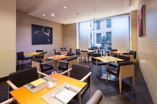 热那亚贝斯特韦斯特PLUS城市酒店的餐厅设有桌椅和大窗户。