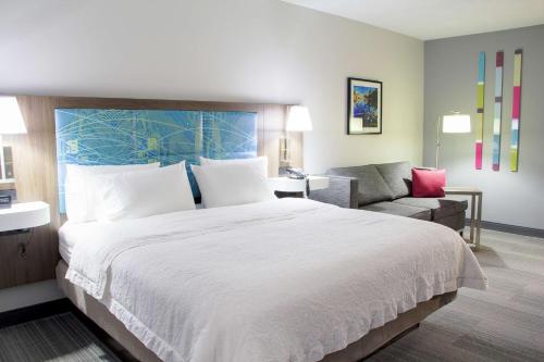 丹维尔丹维尔汉普顿酒店的酒店客房设有一张大床和一张沙发。