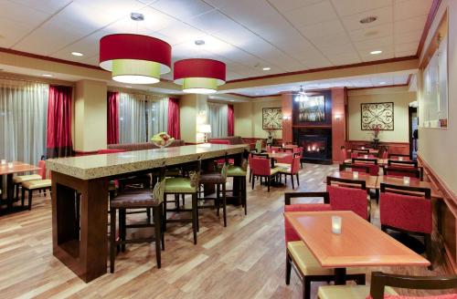 恩波里亚恩波里亚汉普顿酒店的餐厅设有酒吧和桌椅
