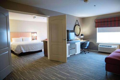 弗雷斯诺弗雷斯诺希尔顿恒庭旅馆&套房酒店的酒店客房,配有床和电视