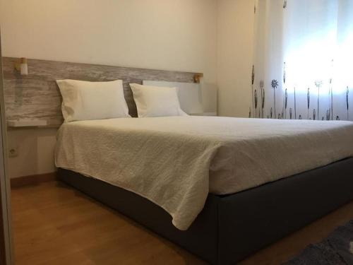 布拉干萨My City House的卧室配有一张带白色床单和枕头的大床。
