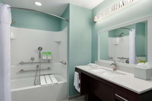 佛罗伦萨佛罗伦萨希尔顿欣庭套房酒店的带浴缸、水槽和镜子的浴室