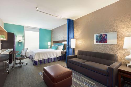 佛罗伦萨佛罗伦萨希尔顿欣庭套房酒店的酒店客房,配有床和沙发