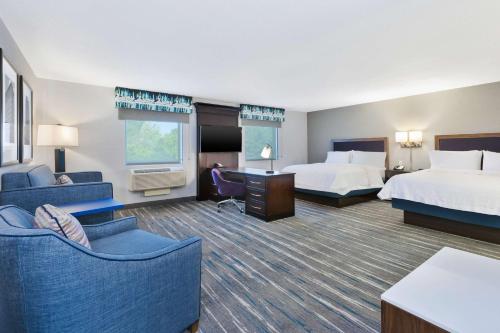 弗林特弗林特格朗德布兰科汉普顿套房旅馆的酒店客房,设有两张床和一张沙发