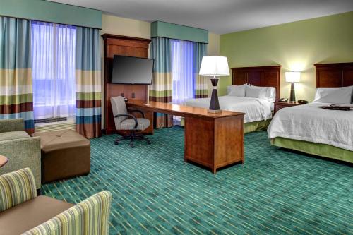 West Dixie Bend椰子溪汉普顿套房酒店的酒店客房配有两张床和一张书桌