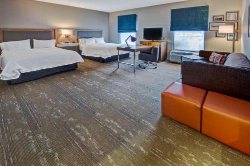埃斯特罗埃斯特罗迈尔斯堡汉普顿酒店及套房的酒店客房,设有两张床和一张沙发