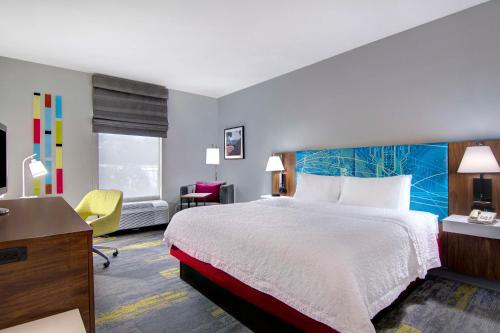 费耶特维尔费耶特维尔汉普顿酒店的配有一张床和一张书桌的酒店客房