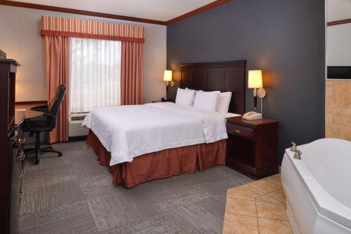 格林维尔格林维尔希尔顿恒庭旅馆&套房酒店的酒店客房配有一张床和浴缸。