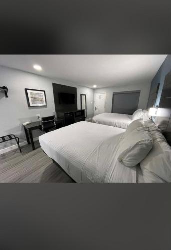 圣安东尼奥Rodeway Inn San Antonio Downtown的酒店客房配有两张床和一张书桌