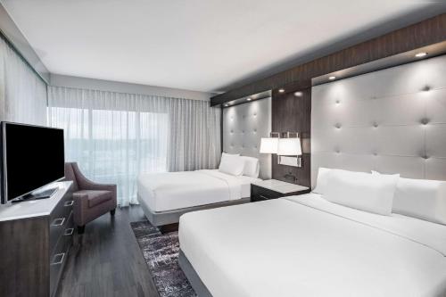 休斯顿Embassy Suites by Hilton Houston-Energy Corridor的酒店客房设有两张床和一台平面电视。