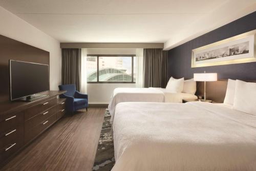 印第安纳波利斯Embassy Suites by Hilton Indianapolis Downtown的酒店客房设有两张床和一台平面电视。