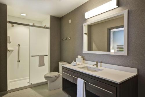 昆斯伯里Home2 Suites by Hilton Queensbury Lake George的一间带水槽、卫生间和镜子的浴室