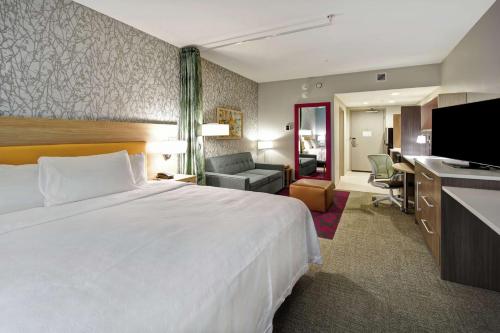 法兰克福Home2 Suites By Hilton Frankfort的酒店客房设有一张大床和一台电视。