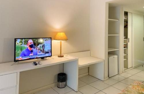 布希奥斯Búzios beach resort的一间配备有书桌的客房,配备有一台电视。