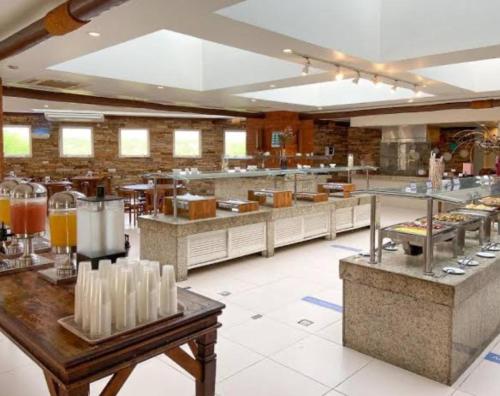 布希奥斯Búzios beach resort的一间大型餐厅,内设一间供应食物的大厨房
