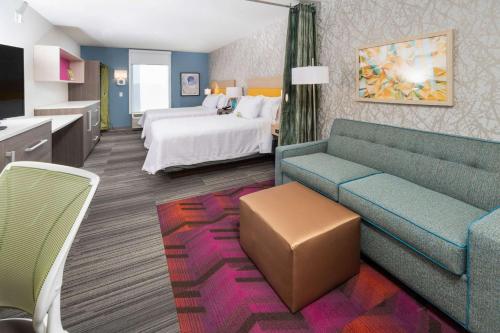 纽瓦克Home2 Suites By Hilton Newark Airport的酒店客房,配有床和沙发