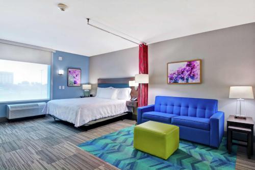斯普林代尔Home2 Suites By Hilton Springdale的酒店客房,配有床和蓝色的沙发