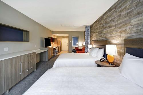 休斯顿Home2 Suites Houston Westchase的酒店客房设有两张床和一台平面电视。