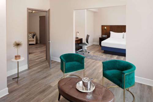 拉威Watt Hotel Tapestry Collection by Hilton的酒店客房带一张床、一张桌子和椅子