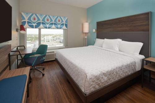 劳德代尔堡Tru By Hilton Fort Lauderdale Downtown-Flagler Village的一间卧室配有一张床、一张桌子和一把椅子