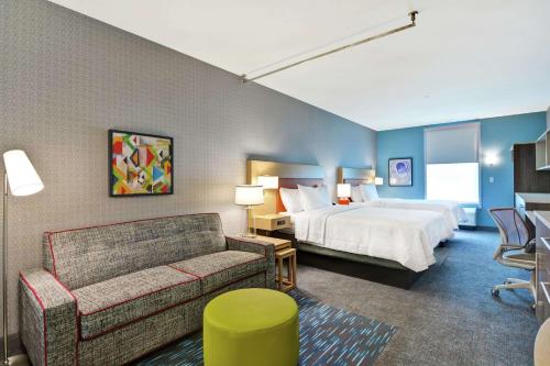 杰克逊维尔Home2 Suites By Hilton Jacksonville South St Johns Town Ctr的酒店客房,配有床和沙发