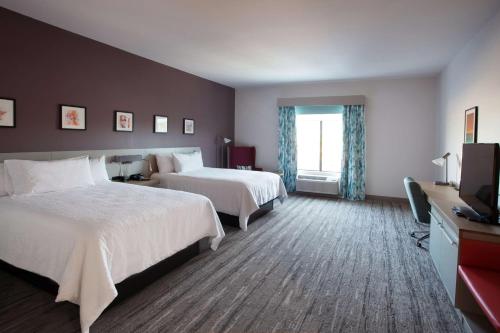 AberdeenHilton Garden Inn Southern Pines Pinehurst, Nc的酒店客房设有两张床和电视。