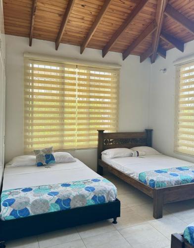 比亚维森西奥Cabaña La Betica的配有百叶窗的客房内的两张床