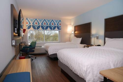 钱伯斯堡Tru By Hilton Chambersburg的酒店客房设有两张床和窗户。