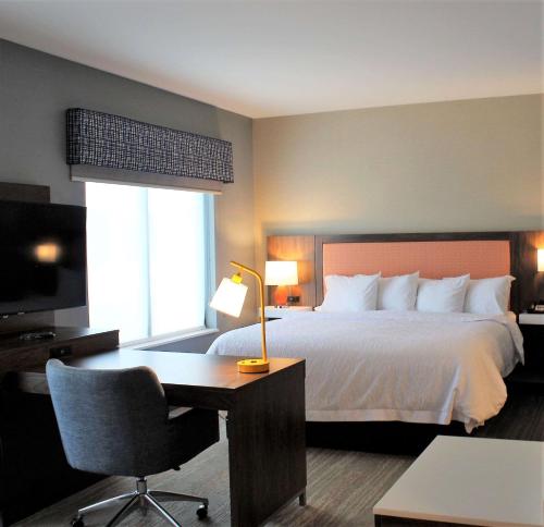 列克星敦Hampton Inn Lexington的酒店客房配有一张床、一张书桌和一张书桌。