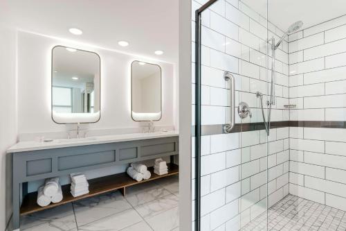 埃尔克哈特Hotel Elkhart, Tapestry Collection By Hilton的一间带两个盥洗盆和淋浴的浴室