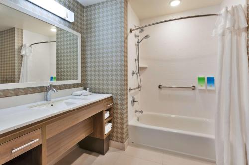 大布兰克Home2 Suites By Hilton Grand Blanc Flint, Mi的带浴缸、水槽和淋浴的浴室