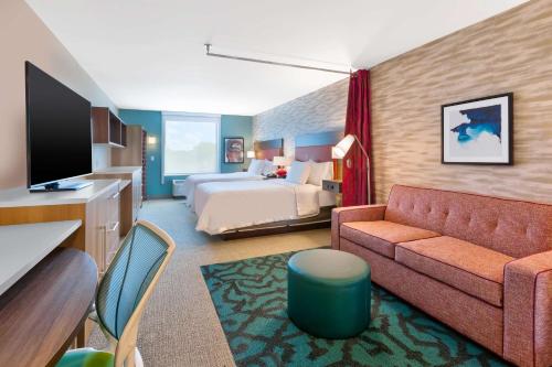 大布兰克Home2 Suites By Hilton Grand Blanc Flint, Mi的酒店客房,配有床和沙发
