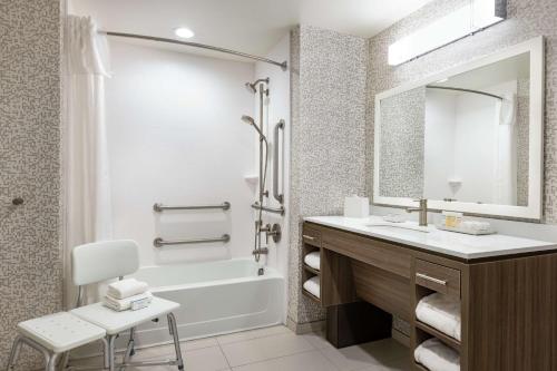 新不伦瑞克Home2 Suites by Hilton New Brunswick, NJ的一间带水槽、浴缸和镜子的浴室