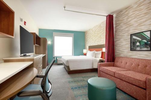 新不伦瑞克Home2 Suites by Hilton New Brunswick, NJ的酒店客房,配有床和沙发