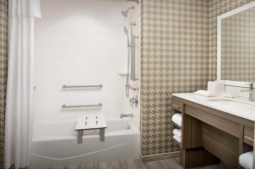 迈尔斯堡Home2 Suites by Hilton Fort Myers Airport的带浴缸、淋浴和盥洗盆的浴室