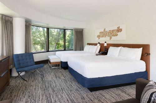 费尔法克斯Hilton Fairfax, Va的酒店客房,配有两张床和椅子