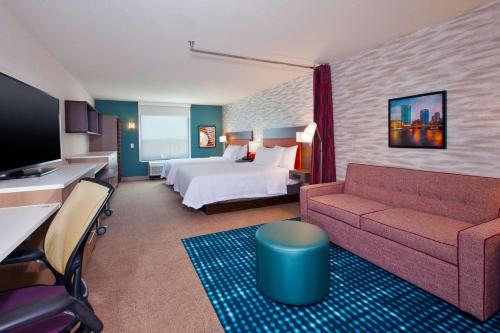 Byron CenterHome2 Suites By Hilton Grand Rapids South的酒店客房,配有床和沙发