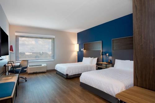 圣露西港Tru By Hilton Port St Lucie Tradition的酒店客房设有两张床和窗户。