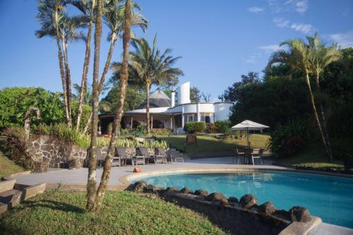 BellavistaRoyal Palm Galapagos, Curio Collection Hotel by Hilton的棕榈树屋前的游泳池