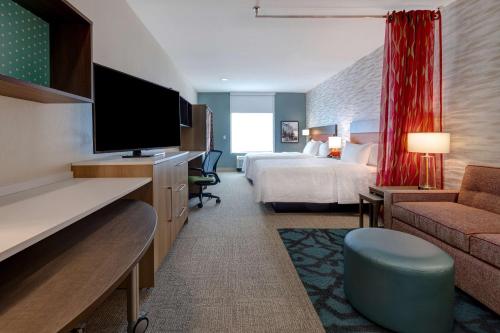 加尔维斯敦Home2 Suites Galveston, Tx的配有一张床和一台平面电视的酒店客房
