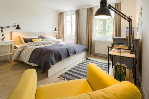 GarzHerthaquelle Wohnung 1 "Studio H"的一间卧室配有一张床和一张黄色的沙发