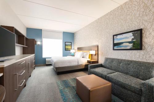 利斯堡Home2 Suites By Hilton Leesburg, Va的酒店客房,配有床和沙发