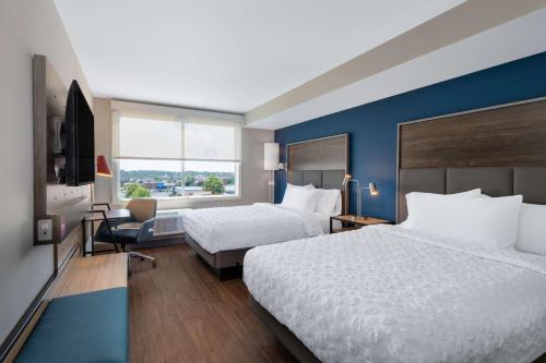费耶特维尔Tru By Hilton Fayetteville Fort Bragg的酒店客房设有两张床和窗户。