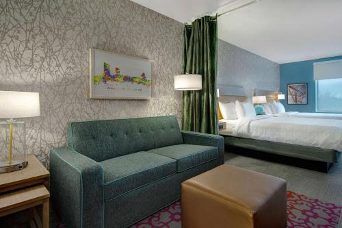 肯特伍德Home2 Suites By Hilton Grand Rapids Airport的酒店客房设有一张沙发和一张床