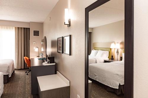纽瓦克Hampton Inn & Suites By Hilton- Newark Airport Elizabeth的酒店客房,设有两张床和镜子