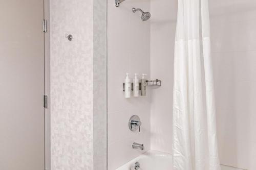 纽瓦克Hampton Inn & Suites By Hilton- Newark Airport Elizabeth的一间带白色淋浴帘的浴室